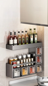 Detail view of wall-mounted black matte spice rack with seasoning drawers and hooks
