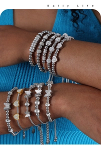 Vue détaillée des bracelets à perles superposés cœur et papillon avec zircons