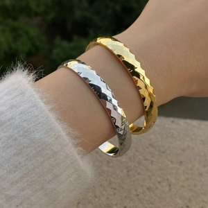 Minimalist gold and silver stainless steel bangles with geometric faceted texture