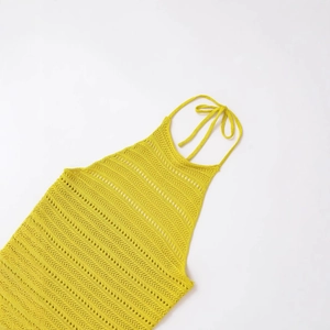 Bright yellow knit halter top with textured hollow design on white background