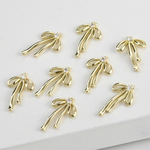 Macro shot of 14k gold-plated bow pendants with sparkling cubic zirconia for DIY jewelry
