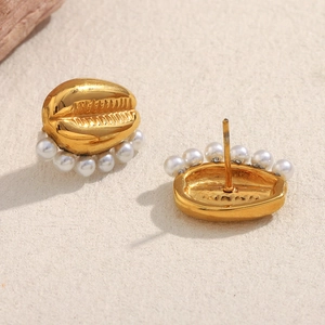 Detailed view of gold plated tooth shaped earrings with small white imitation pearls