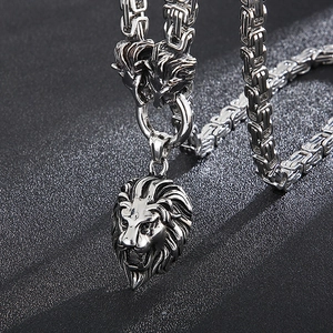 Macro shot of silver lion head pendant with intricate Byzantine chain craftsmanship