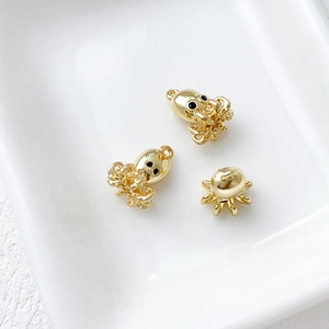 Three 14k gold plated octopus pendants in a white ceramic dish for DIY jewelry making