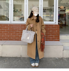 Chic lifestyle view of large lamb wool tote bag carried by model in casual street setting