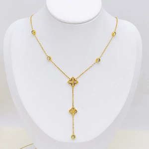 Collier doré à double pendentif fleur avec perles et strass sur mannequin à bijoux
