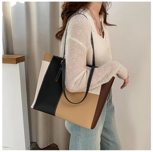 Detailansicht der farbblockierten Einkaufstasche in Beige Braun und Schwarz am Modell