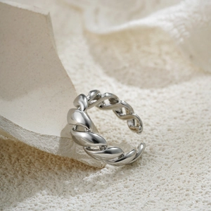 Close-up of adjustable silver twisted woven ring featuring a smooth metallic finish