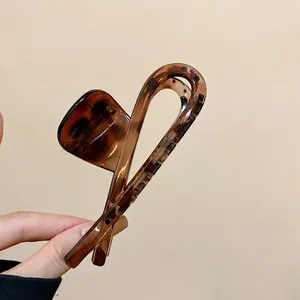 Classic tortoise shell claw clip in brown resin for elegant hair styling and buns