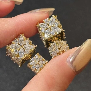Close-up of golden square earrings with marquise-cut sparkling cubic zirconia crystals