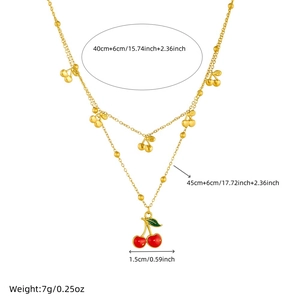 Double-layered gold cherry necklace with red enamel pendants on a clean white backdrop
