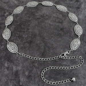 Detail of vintage silver metal waist chain featuring carved floral oval links and lobster clasp