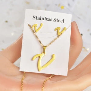 Dettaglio di un set di gioielli in acciaio inossidabile dorato con collana a V e orecchini