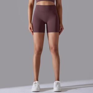 Detail of high-waist seamless brown yoga shorts with wide waistband on model