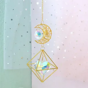 Golden moon and heart crystal suncatcher pendant hanging against dreamlike background