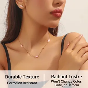 Close-up of pink enamel lotus flower necklace and earrings set worn by a female model