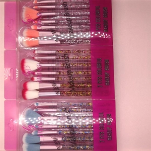 Three sets of 7-piece glitter handle makeup brushes in pink, blue, and red PVC packaging