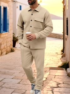 Detail of men's casual beige two-piece set showing waffle texture on a coastal street