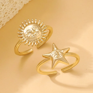 Close-up of gold adjustable rings featuring celestial sun and star face designs