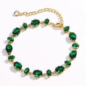 Detail of gold bracelet with 16 oval green zircon stones and claw setting on white background