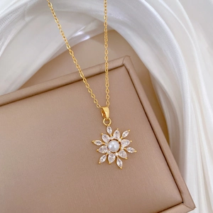 Detailed close-up of gold flower necklace with pearls and zircons on white silk background