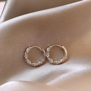 Boucles d'oreilles créoles torsadées en argent avec oxydes de zirconium sur soie satinée