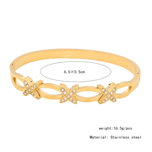Vista dettagliata di un bracciale in acciaio dorato con motivi a X diamantati e misure