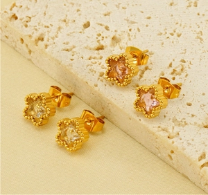 Close-up of gold star stud earrings with sparkling cubic zirconia and beaded edges