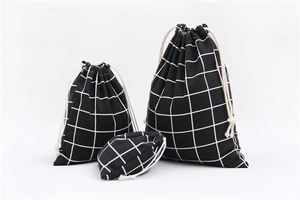 Close-up of three cotton linen drawstring bags with black and white grid patterns