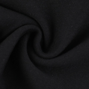Vue macro de la texture du tissu en maille noire avec drapé naturel pour haut cintré sexy