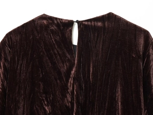 Détail d'un haut en velours marron foncé avec plis verticaux et col à bouton discret
