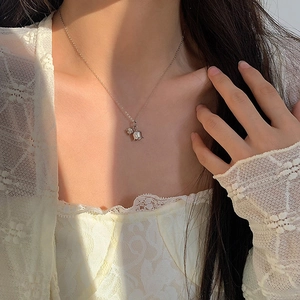 Macro shot of lily of the valley flower pendant on neck with elegant sunlight reflections
