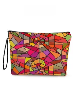 Detail view of colorful geometric cosmetic bag with black zipper and wristlet strap
