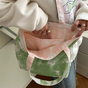 Dettaglio della borsa tote in tela tie-dye con fodera arancione e tasca interna