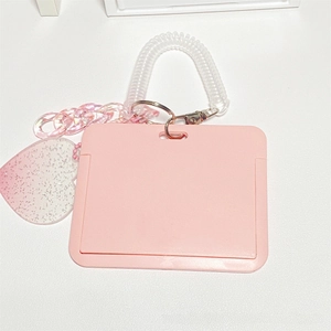 Pink heart pendant with glitter detail and a transparent spiral wrist strap on a card holder