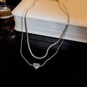 Detail of silver double-layered heart choker with flat snake chain and glossy metal pendant