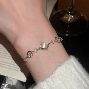 Detail of gold-plated flower bracelet with cat-eye stone and cubic zirconia inlay