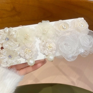 Close-up of elegant white fabric flower hair clips set with pearls and rhinestones