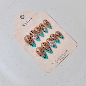 Detail of almond nails with leopard print and 3D pink resin flower decorations