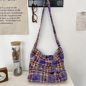 Détail du sac en toile à carreaux violets avec boutons vintage et étiquette de marque