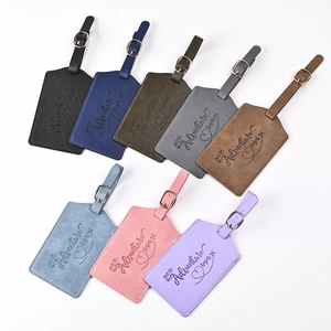 Flat lay of eight colorful PU leather luggage tags with adventure begins engraving