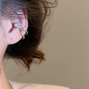 Close-up of double-layer silver ear cuff with sparkling zircon stones on female ear