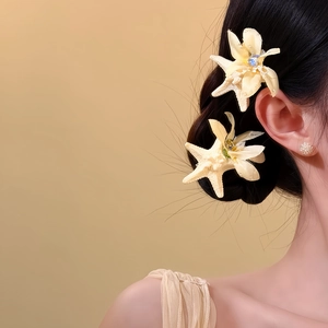 Detailansicht von eleganten Haarclips mit cremefarbenen Stoffblumen und Seesternen