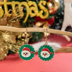 Close-up of Santa Claus earrings hanging on a festive Christmas tree decoration