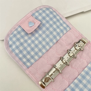Detail of pink quilted and blue gingham fabric binder with 6-ring metal mechanism