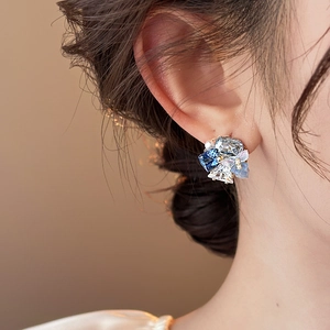 Blue crystal floral cluster earrings with 18k gold plating and white pearls worn by model