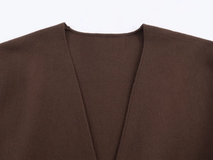 Vista macro dettagliata dello scollo a V e della trama a maglia liscia del cardigan marrone