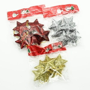 Close-up of glittery red, gold, and silver 5cm Christmas star ornaments in packaging