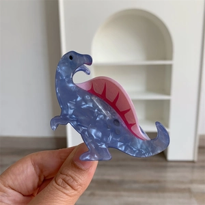 Close-up of cute marble textured dinosaur hair claw clip in purple and pink finish