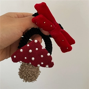 Cute red mushroom hair tie and velvet bow hair clip set held in hand for girls